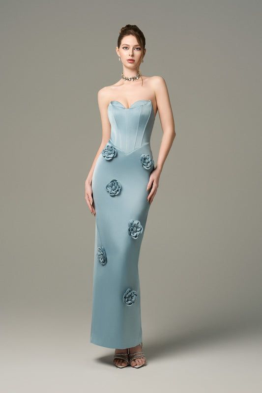 The  Turquoise Silk Floral Applique Maxi Dress is crafted from high-quality silk, featuring hand-sewn 3D floral appliqués cascading down the skirt.