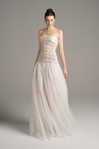 Angled front view of strapless drop waist maxi dress with sheer criss-cross bodice and tulle skirt