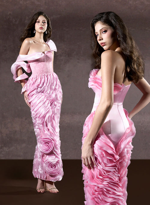Woman wearing a pink floral evening gown against a brown background