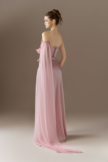 The back view of a vibrant red figure-hugging maxi dress, showcasing its sleek silhouette and the detachable single cape sleeve on the left side.